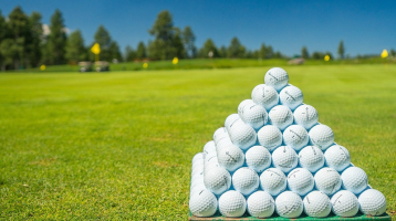 Pyramid of golf balls on golf course driving range