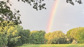 rainbow over golf course green